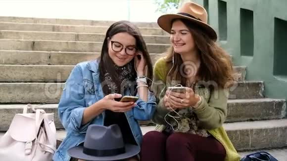 两位女性朋友分享智能手机听音乐和跳舞视频的预览图