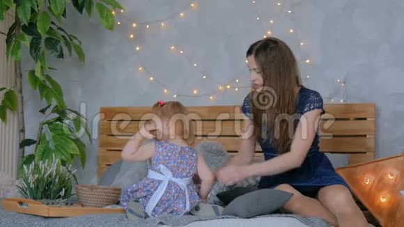 快乐的年轻母亲和她的宝贝女儿在玩致谢乐视频的预览图