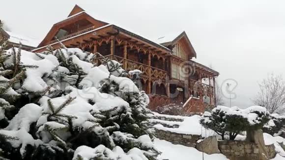 大雪时山村的木屋背景为针叶林落在木头上的雪视频的预览图