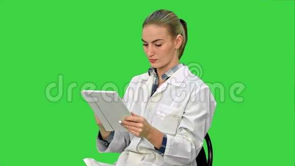 女医生在绿色屏幕上制作数字平板电脑Chroma键视频的预览图