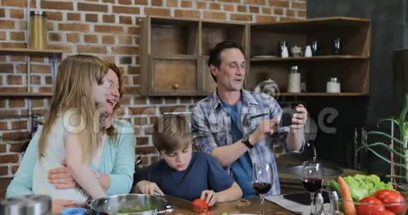 父亲在厨房里为自己拍摄快乐的家庭烹饪照片一起在家准备饭菜视频的预览图