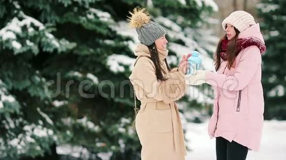 在美丽的冬雪天年轻的女人们在户外举着烛光尽情享受视频的预览图