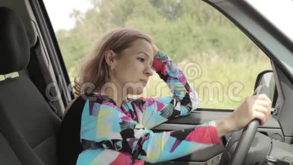 美丽的金发女人开车打电话视频的预览图
