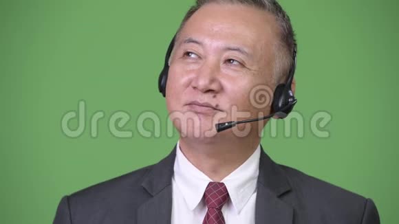 成熟的日本商人在绿色背景下担任呼叫中心代表视频的预览图