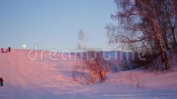 冬季景观日落时间人们爬上雪山视频的预览图