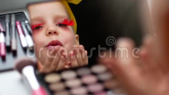 镜子前一个漂亮的小女孩使自己成为一个化妆师视频的预览图