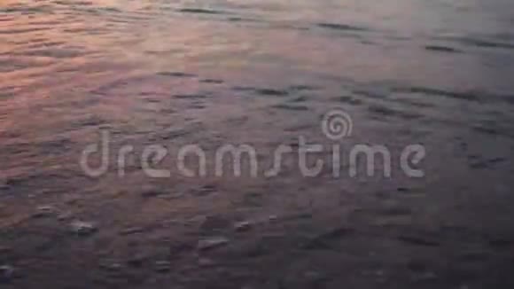 日落时在美丽的沙滩上挥手视频的预览图