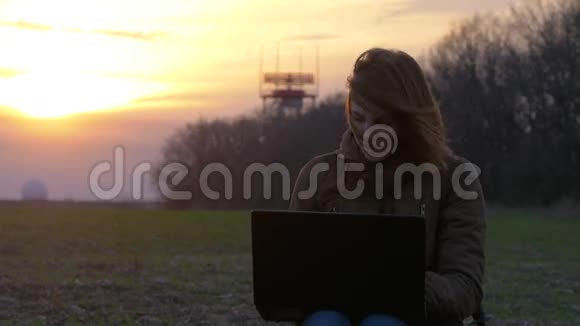 红发女孩在机场雷达附近使用笔记本电脑飞行飞机背景视频的预览图