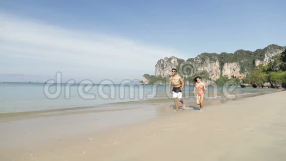 情侣在海滩边奔跑快乐的情侣在海上度假时微笑游客视频的预览图