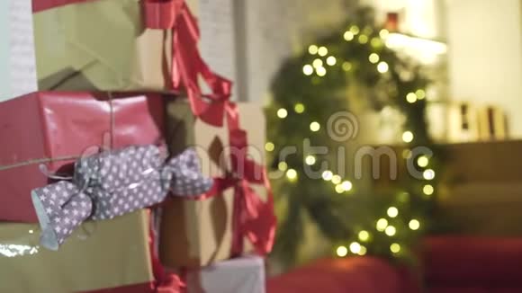 在装饰好的节日气氛房间里新年树上的礼物堆在包裹好的圣诞礼物上视频的预览图