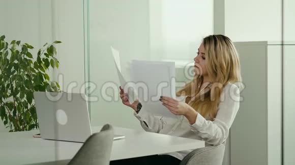 年轻的女商人在明亮的办公室里看文件视频的预览图