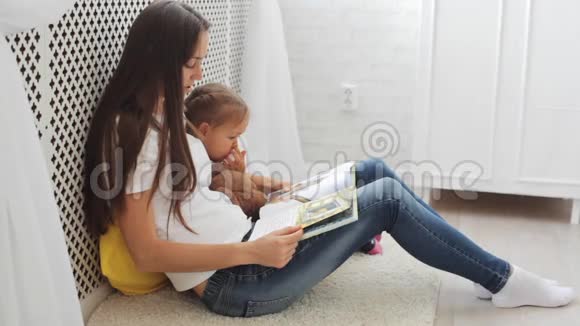 年轻的母亲为她的小女儿读书视频的预览图