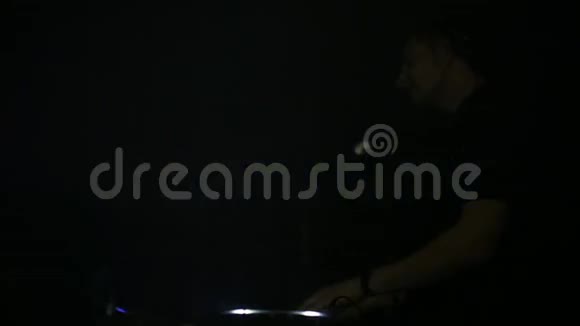 在音乐面板上播放的DJ的肖像侧视夜总会里的音乐剧DJ营造了视频的预览图