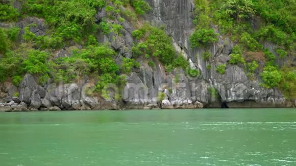越南的海湾越南越南美丽的大自然水中的绿色岩石小船漂过海湾岩石A视频的预览图