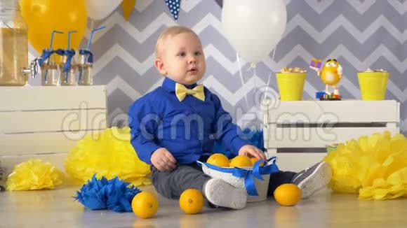 小男孩正拿着柠檬的花瓶坐在地板上视频的预览图