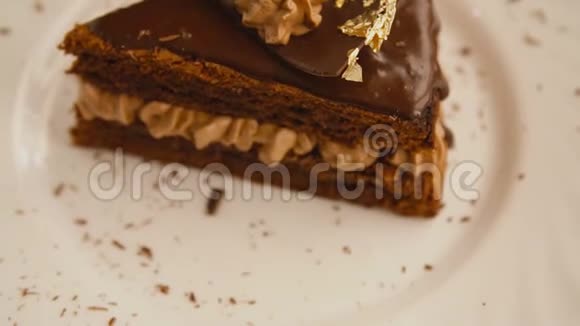 一片巧克力蛋糕放在旋转的白色盘子里视频的预览图