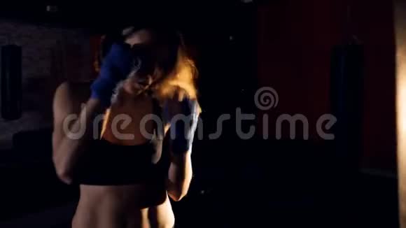那个女拳击手正在用拳击袋训练特写镜头4K视频的预览图