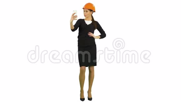 年轻的女建筑师戴着头盔在白色背景下打电话自拍视频的预览图