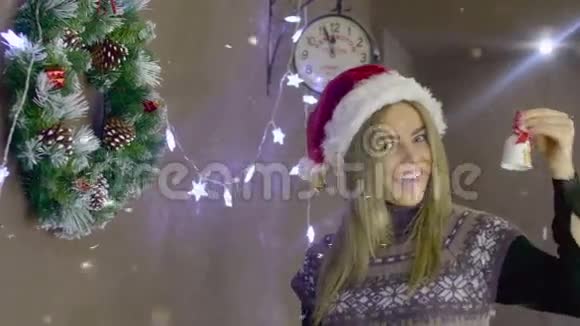 美丽的金发女孩按铃在圣诞装饰的背景下圣诞节快到了视频的预览图