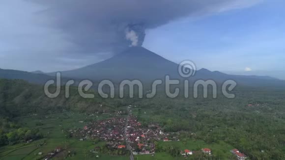 灰烬从火山中升起热带丛林中火山山脚下的村庄视频的预览图