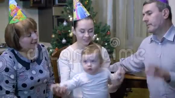 热爱年轻的妈妈和爷爷奶奶和坐在椅子上的1岁玩耍快乐的妈妈抱着视频的预览图