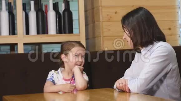 妈妈和可爱的小女孩在咖啡馆吃早餐视频的预览图