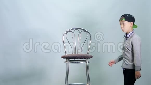 男孩爬上高高的椅子表演课视频的预览图