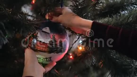 用漂亮的年轻女士的双手用大球装饰圣诞树视频的预览图