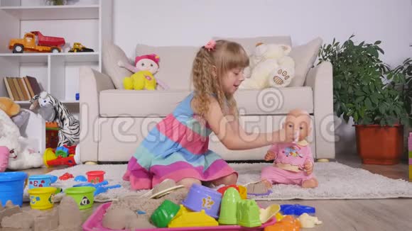 一个女孩用塑料勺子喂娃娃视频的预览图