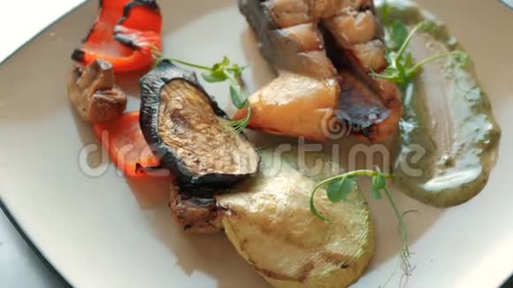 在餐馆里厨师从一条三文鱼烤蔬菜和排骨中准备饭菜概念视频的预览图
