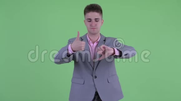 困惑的年轻商人在竖起大拇指和竖起大拇指之间做出选择视频的预览图