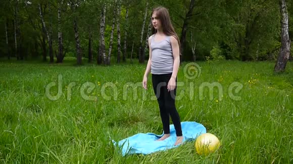 年轻漂亮的青少年女孩在户外练习健身运动在夏天的公园里高清拍摄静态摄像机视频的预览图