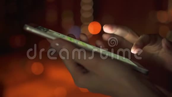 夜间在城市户外使用智能手机触摸屏的女性手部特写输入信息视频的预览图