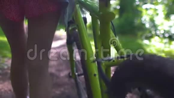 年轻女子在美丽的日出期间骑自行车在树林里慢动作视频的预览图