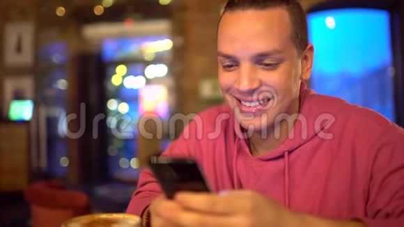 迷人的西班牙裔男人一个商人一个学生或一个创业公司用手机带着迷人的微笑帅哥视频的预览图