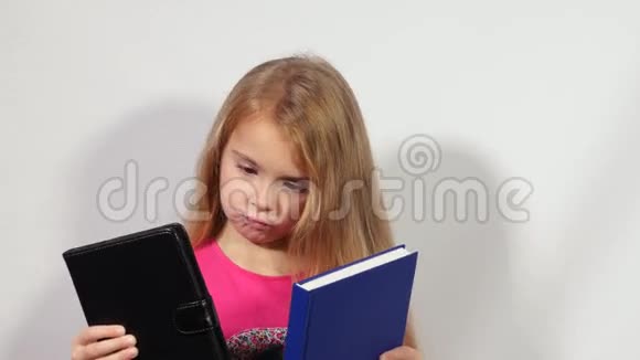小女孩在书和桌子之间选择视频的预览图