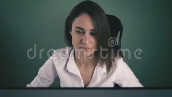 穿白衬衫的年轻女子在办公室电脑工作的肖像视频的预览图