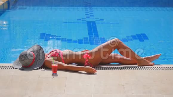 一位女士在游泳池附近放松的侧景视频的预览图