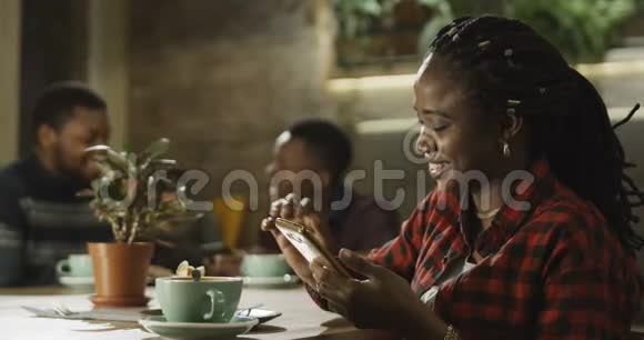 年轻的黑人妇女在用手机说话视频的预览图