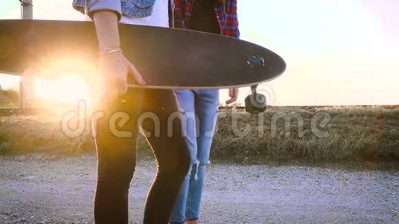 两个年轻漂亮的女人用滑板走路说话视频的预览图
