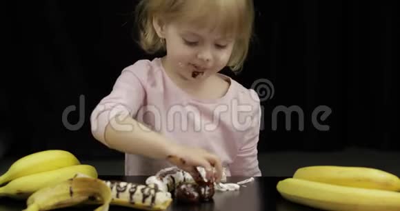 孩子们吃香蕉草莓融化的巧克力和鲜奶油视频的预览图