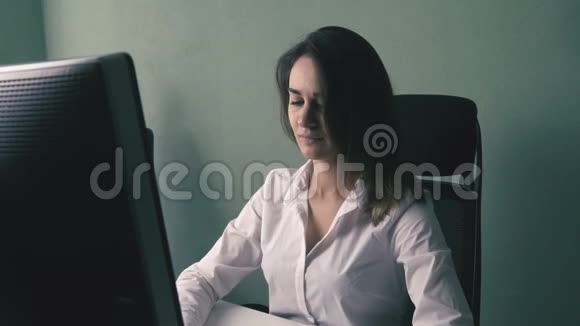 女商人穿着白衬衫在办公室电脑工作的肖像视频的预览图