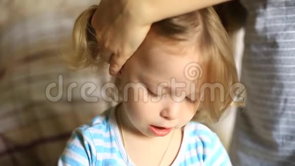 妈妈给蓝眼睛的小女孩梳头视频的预览图
