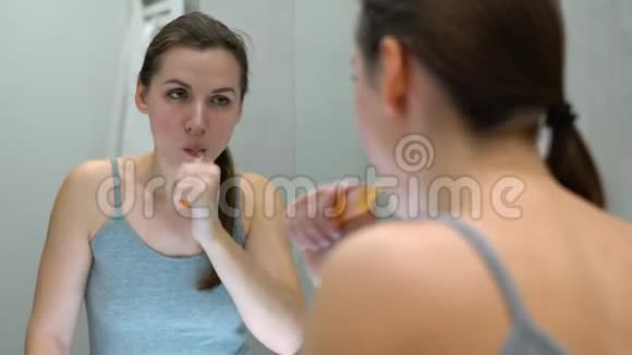 漂亮的女人早上在浴室刷牙早上的卫生视频的预览图