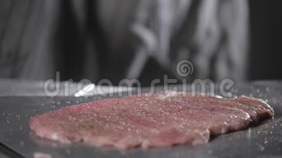 把盐放进去维纳施尼泽尔生猪肉准备用油腌料在煎锅里用火煮专业人员视频的预览图