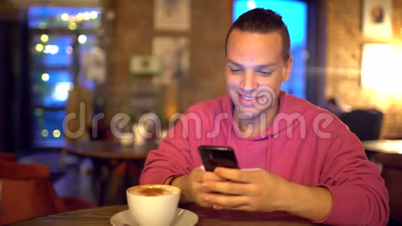 迷人的西班牙裔男人一个商人一个学生或一个创业公司用手机带着迷人的微笑帅哥视频的预览图