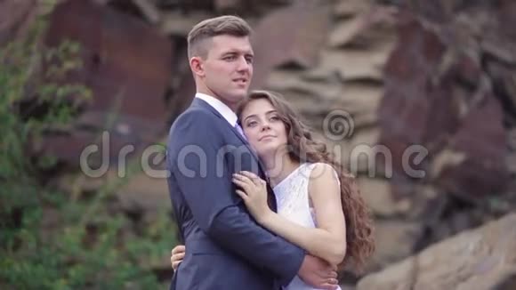 新娘和新郎拥抱在山上的背景下举行婚礼视频的预览图