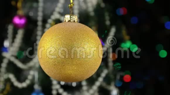 美丽的黄色新年和圣诞装饰球在绳子上摆动视频的预览图