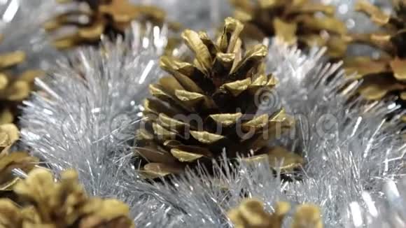 特写旋转的银质和金色松果光反射在金属罐里视频的预览图