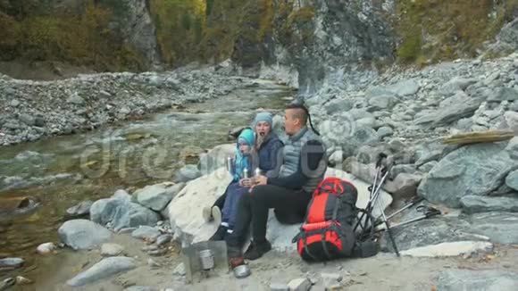 游客在徒步旅行后休息家庭旅行人的环境由山河溪组成父母和孩子走路视频的预览图